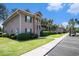 Attractive condo building featuring green shutters and palm trees adjacent to a parking area at 342 Pinehurst Ln. # 12J, Pawleys Island, SC 29585