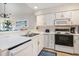Updated kitchen features white cabinetry, modern appliances, and stainless steel sink with island at 342 Pinehurst Ln. # 12J, Pawleys Island, SC 29585