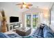 Cozy living room features a large sectional sofa, flat screen television, and access to the outdoor balcony at 342 Pinehurst Ln. # 12J, Pawleys Island, SC 29585