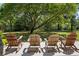 Relaxing back patio with four wooden chairs underneath a shady tree canopy at 352 Old Carriage Loop, Georgetown, SC 29440