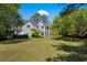 Spacious backyard with lush green grass and mature trees surrounding a beautiful home at 352 Old Carriage Loop, Georgetown, SC 29440
