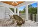 Inviting outdoor porch features wicker seating with stunning views of the green landscape at 352 Old Carriage Loop, Georgetown, SC 29440