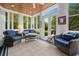Bright sunroom with wood ceiling, wicker furniture, and views of the manicured backyard at 352 Old Carriage Loop, Georgetown, SC 29440