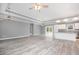 Open-concept living room with tray ceiling, wood-look floors, and view into kitchen at 357 Log Cabin Rd., Loris, SC 29569