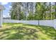 Green backyard with a tall privacy fence bordering a line of mature pine trees at 3725 Park Pointe Ave., Little River, SC 29566