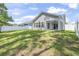 Expansive backyard featuring lush green grass, a white picket fence, and mature trees at 3725 Park Pointe Ave., Little River, SC 29566