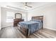 Bright bedroom with a tray ceiling, ceiling fan, and light gray wood-look flooring at 3725 Park Pointe Ave., Little River, SC 29566