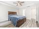Bright bedroom with a tray ceiling, ceiling fan, and light gray wood-look flooring at 3725 Park Pointe Ave., Little River, SC 29566