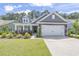 Charming home featuring a two-car garage, stone accents, and a well-manicured front lawn at 3725 Park Pointe Ave., Little River, SC 29566