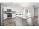 Bright kitchen features white cabinets, stainless steel appliances, a gray backsplash, and an island with a marbled countertop at 3725 Park Pointe Ave., Little River, SC 29566