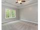 Bright bedroom with a tray ceiling, ceiling fan, plush carpet, and large window at 375 Log Cabin Rd., Loris, SC 29569