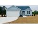 Charming single-story home featuring light blue siding, a two-car garage, and manicured front lawn at 375 Log Cabin Rd., Loris, SC 29569