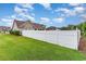 Backyard featuring a well-maintained lawn and a white fence, creating a private outdoor space at 3757 Kingsley Dr., Myrtle Beach, SC 29588