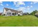 Spacious backyard featuring a well-maintained lawn, a large stone patio and a white pergola at 400 Palo Verde Dr., Myrtle Beach, SC 29579