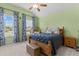 Bedroom featuring a bed with blue covers, a hanging chair, and natural light from the windows at 400 Palo Verde Dr., Myrtle Beach, SC 29579
