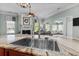 Close-up of kitchen sink with stainless steel faucet, granite countertop, and living room view at 400 Palo Verde Dr., Myrtle Beach, SC 29579