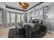 Spacious main bedroom featuring a ceiling fan, tray ceiling, large windows and neutral decor at 400 Palo Verde Dr., Myrtle Beach, SC 29579