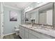 Bathroom with double sinks, granite countertops, framed mirror, and wood-look floors at 448 Papyrus Circle # 448, Little River, SC 29566