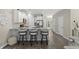 Well-lit kitchen features stainless appliances, breakfast bar with three stools, and wood floors at 448 Papyrus Circle # 448, Little River, SC 29566
