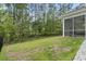 A spacious backyard features a black fence bordering a lush wooded area, offering privacy and a screened porch at 452 Sun Colony Blvd., Longs, SC 29568