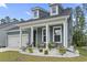 The front of the home showcases white columns and landscaping and a two car garage at 452 Sun Colony Blvd., Longs, SC 29568