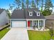 Charming blue home with a red front door, dormer windows and a well-manicured front yard at 452 Sun Colony Blvd., Longs, SC 29568