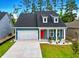 Charming blue home featuring a two-car garage, landscaped front yard, and an inviting red front door at 452 Sun Colony Blvd., Longs, SC 29568