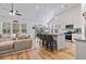 Bright, open living room features a kitchen with an island, natural light, and a modern ceiling fan at 452 Sun Colony Blvd., Longs, SC 29568