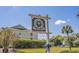 River Oaks Golf & Tennis Resort sign featuring lush landscaping, buildings, and clear blue skies at 453 Red River Ct. # 38 I, Myrtle Beach, SC 29579