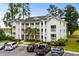 Three-story condo building with white facade, balconies, palm trees, and parking in front at 453 Red River Ct. # 38 I, Myrtle Beach, SC 29579