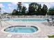 Community pool with jacuzzi, lounge chairs and table sets with umbrellas near surrounding condos at River Oaks Golf Plantation at 453 Red River Ct. # 38 I, Myrtle Beach, SC 29579