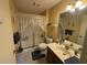 Well-lit bathroom featuring a toilet, shower with lace curtain and a vanity with storage beneath at 5001 Little River Rd. # E-117-119, Myrtle Beach, SC 29577