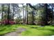 Lush lawn featuring a meandering walkway surrounded by trees and azaleas at 5001 Little River Rd. # E-117-119, Myrtle Beach, SC 29577