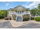 Yellow two-story condo building with shared stairs and landscaping at 5038 Belleglen Ct. # 202, Myrtle Beach, SC 29579