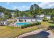 Aerial view featuring a community pool, fenced-in area, pool house and lush surrounding trees at 5038 Belleglen Ct. # 202, Myrtle Beach, SC 29579