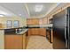 Well-lit kitchen with granite countertops, wooden cabinets, and modern black appliances at 504 N Ocean Blvd. N # 309, Myrtle Beach, SC 29577