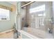 Bright bathroom featuring a large soaking tub with a glass shower door and a tiled surround at 523 Stonemason Dr., Myrtle Beach, SC 29579