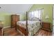 Cozy bedroom featuring hardwood floors, floral-themed decorations, and a four-poster bed at 523 Stonemason Dr., Myrtle Beach, SC 29579