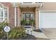 Welcoming front entrance featuring a decorative wreath, potted plants, and a security sign at 523 Stonemason Dr., Myrtle Beach, SC 29579