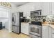 Well-equipped kitchen featuring stainless steel appliances, white cabinets, and tile backsplash at 523 Stonemason Dr., Myrtle Beach, SC 29579