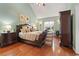Spacious main bedroom with hardwood floors, a large window, and a comfortable king-sized bed at 523 Stonemason Dr., Myrtle Beach, SC 29579