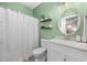 Charming bathroom with decorative shelving, updated vanity, and a refreshing green color scheme at 5750 Oyster Catcher Dr. # 333, North Myrtle Beach, SC 29582