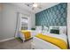Inviting bedroom featuring two beds, a ceiling fan, and a stylish palm leaf accent wall at 5750 Oyster Catcher Dr. # 333, North Myrtle Beach, SC 29582