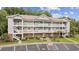 Well-maintained condo building features multiple floors and private balconies, surrounded by lush landscaping and a paved parking lot at 5750 Oyster Catcher Dr. # 333, North Myrtle Beach, SC 29582