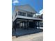 A beautiful white elevated two-story home with a black iron balcony, sturdy stilts, and ample covered parking at 6001 - 1766 S Kings Hwy., Myrtle Beach, SC 29575
