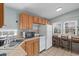 Bright kitchen showcasing oak cabinetry, tile countertops, bar seating, and functional appliances at 6001 - 1807 S Kings Hwy., Myrtle Beach, SC 29575