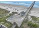 Aerial view of a beach pier featuring blue umbrellas and open ocean views at 6001 N Ocean Blvd. # 342, North Myrtle Beach, SC 29582
