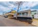 Street view of charming single-story home with neat yard, turquoise door, and proximity to elevated beach houses at 6001-8026 South Kings Hwy., Myrtle Beach, SC 29575