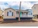 Charming home featuring a welcoming front porch and a brightly colored front door at 6001-8026 South Kings Hwy., Myrtle Beach, SC 29575