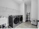 Well-equipped laundry room featuring modern washer and dryer, utility sink, and convenient shelving at 6239 Chadderton Circle, Myrtle Beach, SC 29579